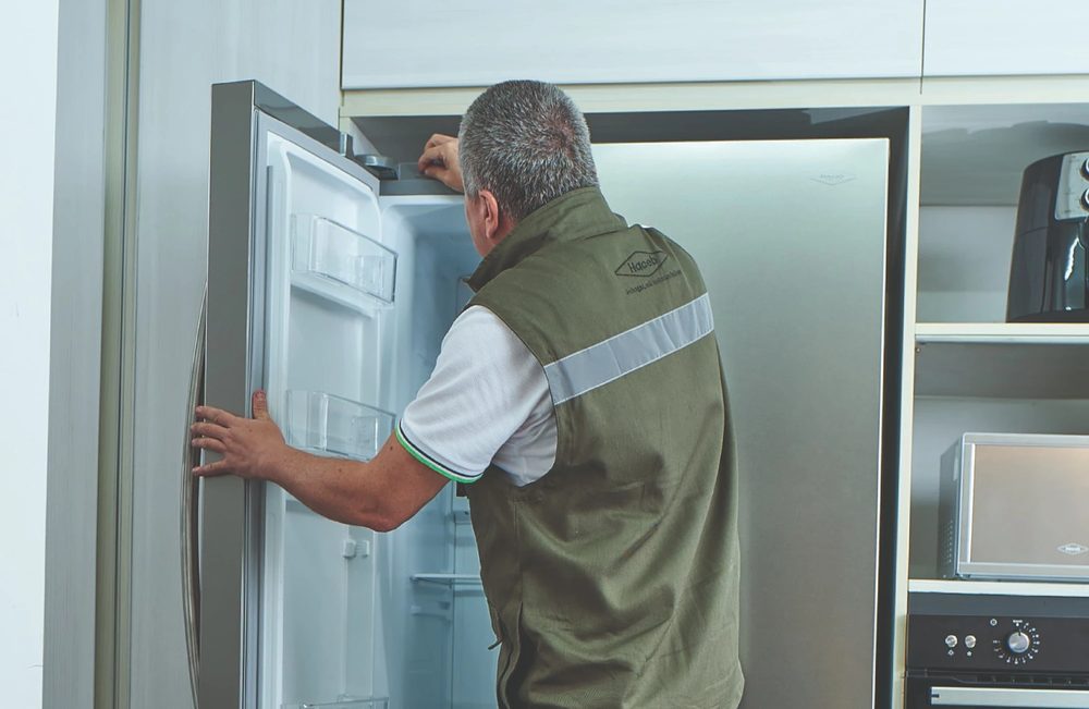 Técnico Haceb revisando el interior de una nevera French Door en una cocina
