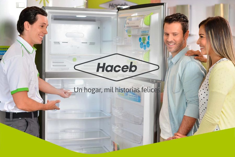 Técnico Haceb explicando a una pareja de clientes el funcionamiento de su nevera